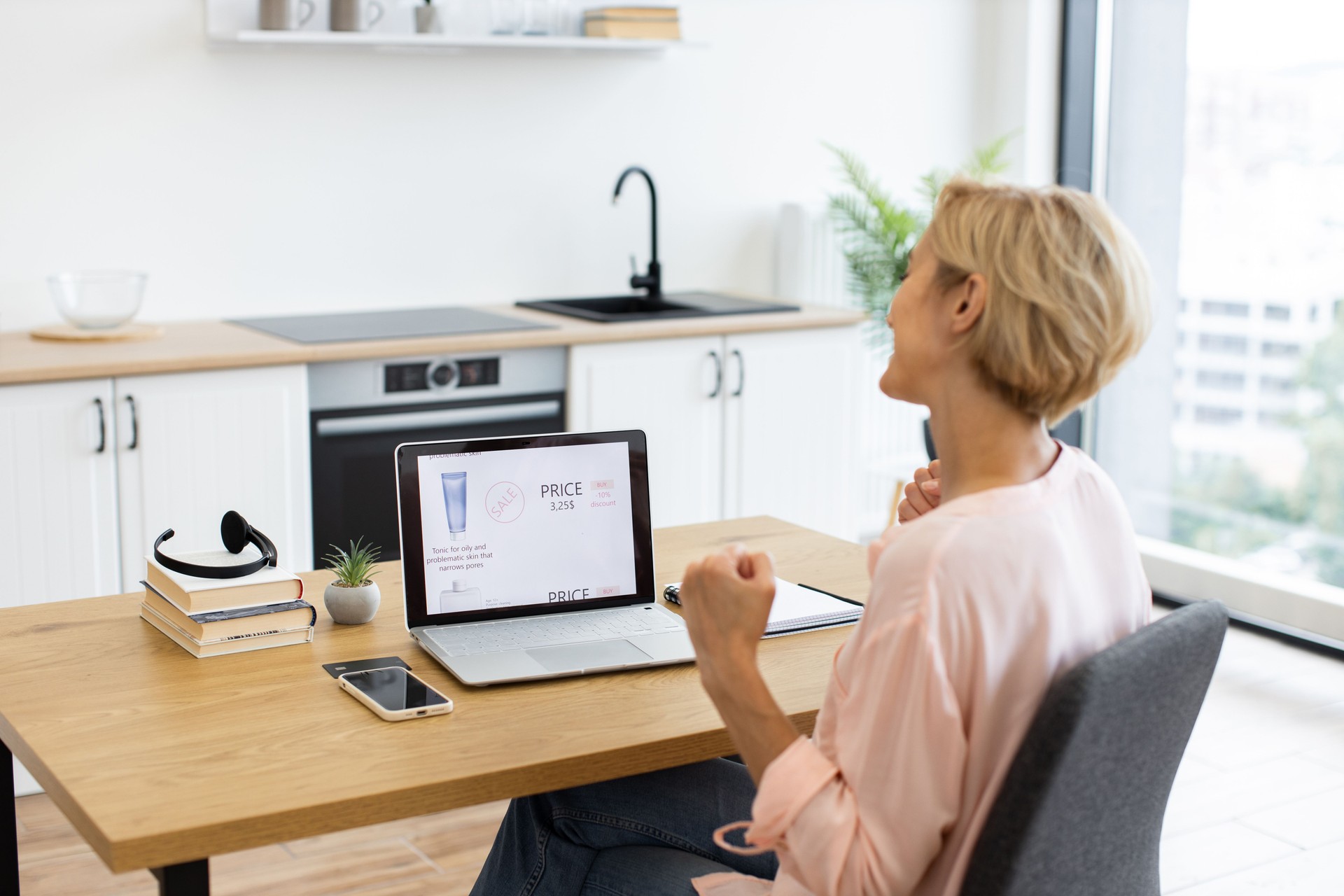 Caucasian woman excitedly ordering cosmetics online on laptop